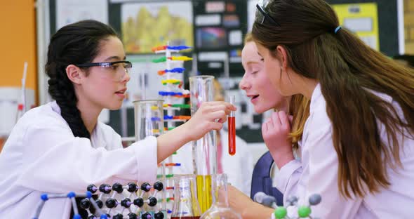 Schoolgirls smelling chemical in laboratory 4k alt
