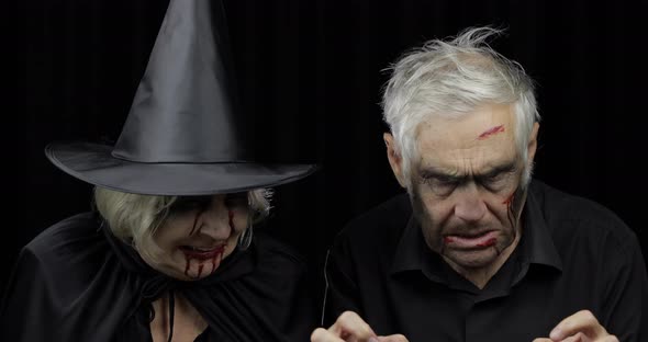Elderly Man and Woman in Halloween Costumes. Witch and Zombie alt