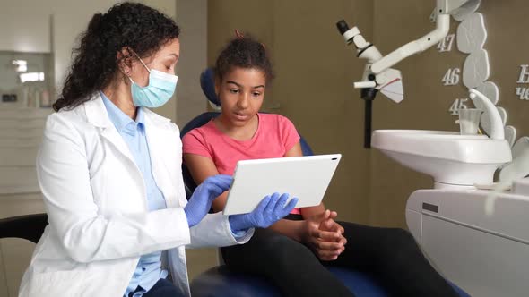 Woman Dentist Showing Dental Xray to Kid Patient alt