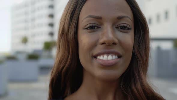 Cheerful African American Woman Looking at Camera on Street alt