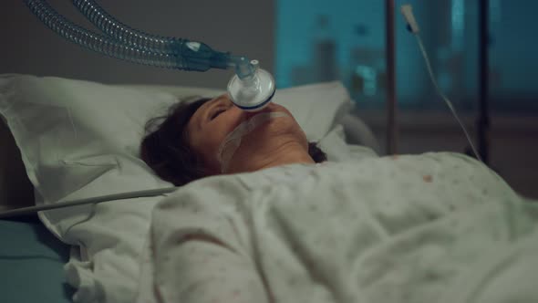 Patient with Oxygen Mask Lying Hospital Bed in Hospital Intensive Care Unit alt