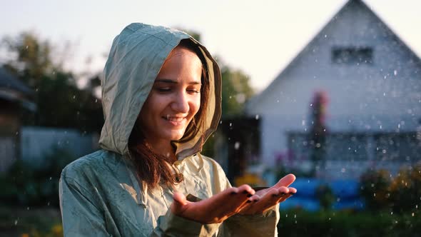Happy Young Woman in Green Raincoat Near Her Country House Enjoying a Calm Rainy Day Breathing Fresh alt