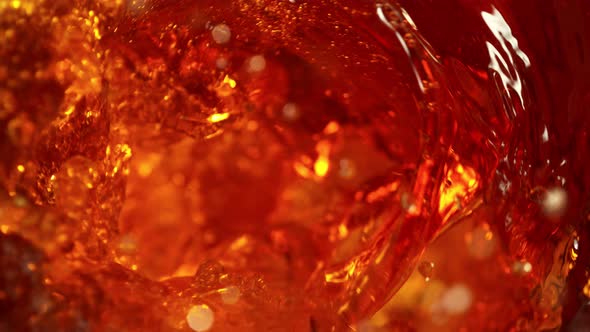 Super Slow Motion Shot of Falling Ice Cubes Into Golden Liquid Vortex at 1000 Fps. alt