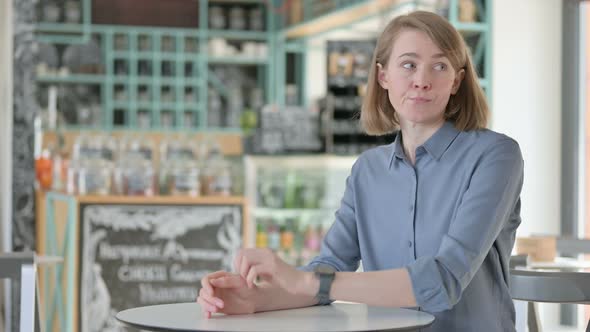 Young Woman Checking Watch While Waiting alt