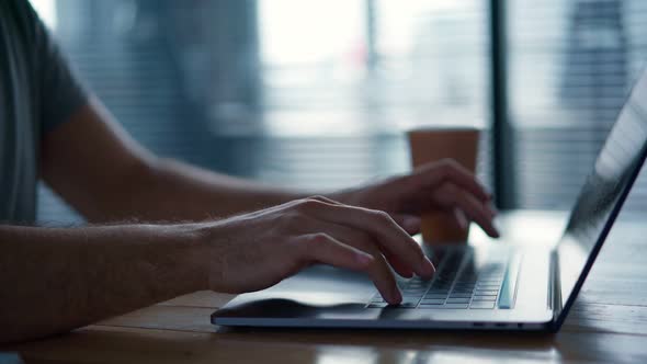 Man's Hands Typing on a Laptop Keyboard alt