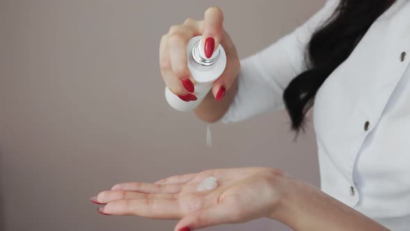 Close Up of Professional Beautician Shows How to Applying Body Lotion Cream on Hands alt