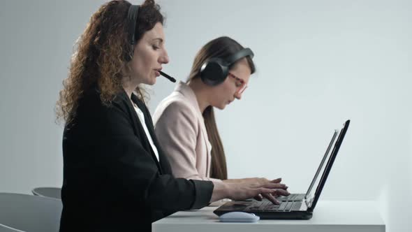 Customer Support Agent or Call Center with Headset Works on Desktop Computer While Supporting the alt