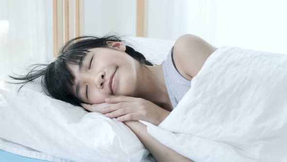 Close up lovely Asian girl sleeping with sweet dream in the bedroom. alt