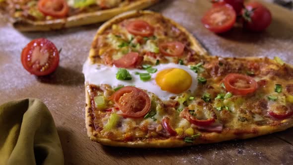 Top View of Two Heart-Shaped Pizzas, Vegetables and Glasses of Wine Arranged for a Romantic Dinner alt