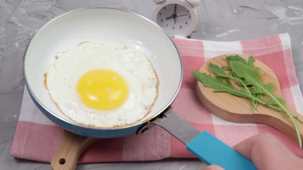 Alarm Clock and Scrambled Eggs on a Grey Background with Space To Copy alt