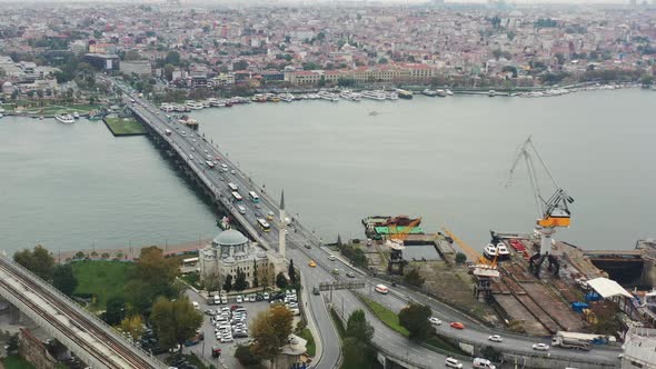 Aerial view of cars and busses crossing Ataturk Bridge over the Bosphorus River next to a mosque on alt
