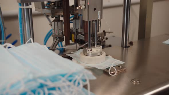 Machine That Glues Elastic Ear Loops Into Polypropylene Medical Masks in Modern Factory