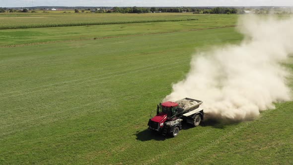 farm tractor spreading white powder low front close up alt