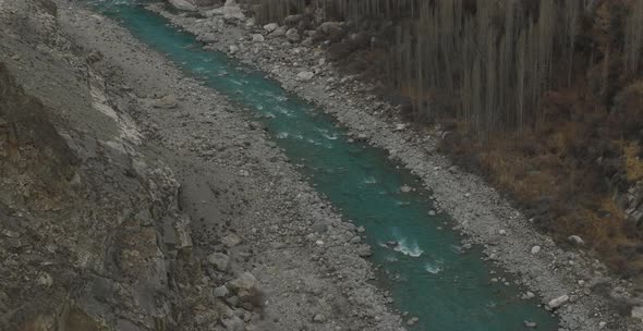 Turquoise River Flowing Through Hunza Valley Floor. Aerial Dolly View alt