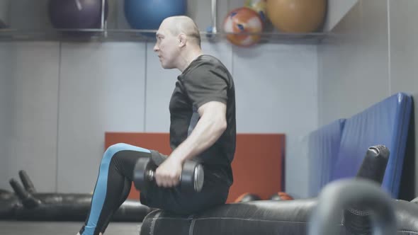 Side View of Confident Man Lifting Hand Weights in Gym. Serious Handsome Caucasian Sportsman alt