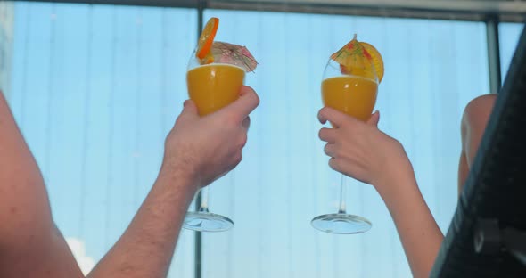 Guy and Lady Hands Clink Transparent Glasses with Cocktails