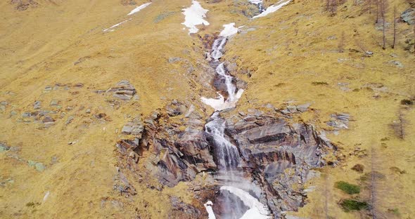 Aerial Flying Moving Backward Away From Waterfall in Yellow Mountain Side Fall Establisher