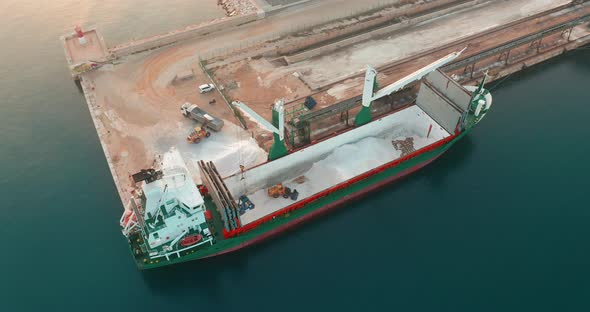 Aerial View. Bulk Carrier Unloading Cargo in Harbor. alt