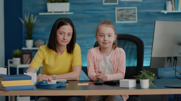 Portrait of Mother and Daughter Sitting at Desk for Homework alt