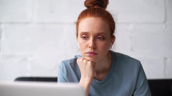 Close-up Face of Exhausted Sleepy Redhead Young Businesswoman Working on Laptop and with Documents. alt