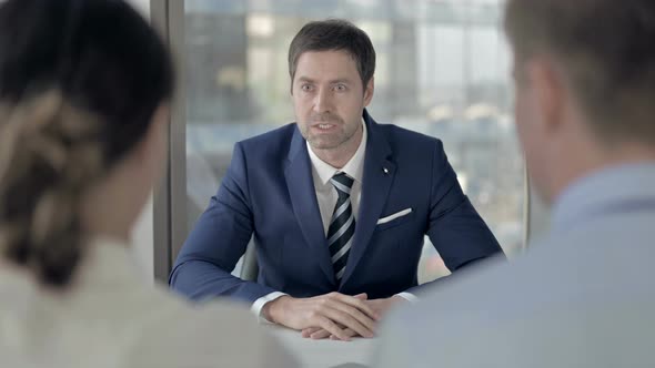 Angry Middle Aged Businessman Talking with Employees at Work alt