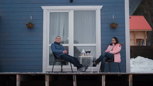 Man and Woman Relaxing on Terrace in Winter alt