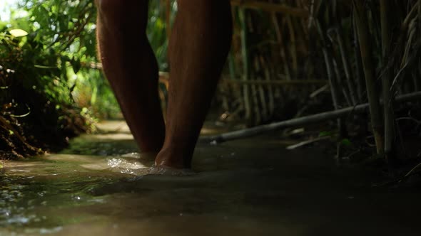 Man Walking Barefoot in Stream of Water in the Forest