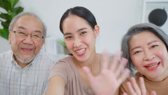 Asian lovely family, daughter use phone video call with senior parents. alt