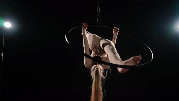 Slim Aerial Gymnast in Split Hanging on Air Hoop Spinning in Slow Motion at Black Background with alt