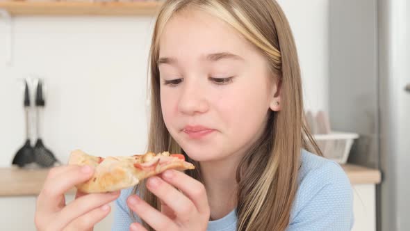 Young Family Deliciously Eating Italian Pizza Sitting in the Kitchen at the Table alt