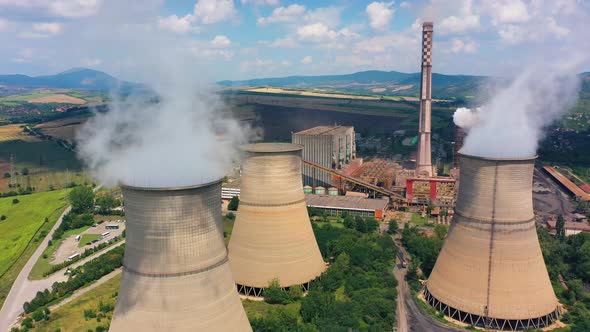 Shot From Drone Of Power Plant Smoking Chimney Against The Blue Sky On The Background