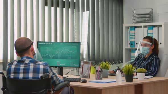 Businesswoman with Face Protection Analysing Financial Statistics alt