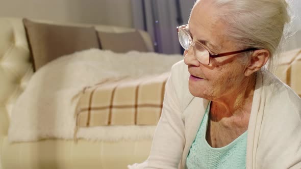 Grandmother Lying on Carpet with Toys around and Looking after Baby