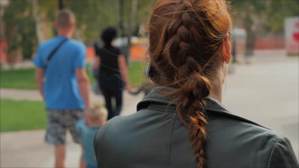Young Woman Drinking Coffee on the Street, Typing Texting a Mobile Phone, While Walking in an Urban