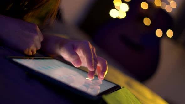 Close up shot of female hand using tablet and touching slide on screen.