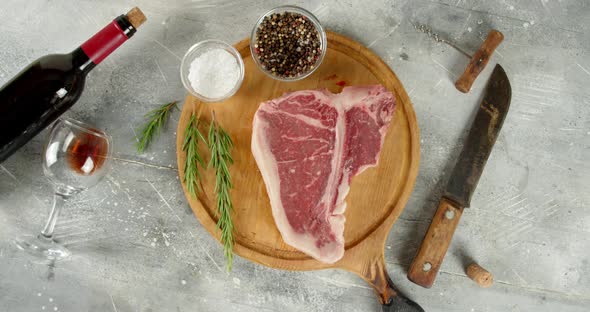 The Steak T-bone Raw Beef on the Cutting Board Rotates  alt