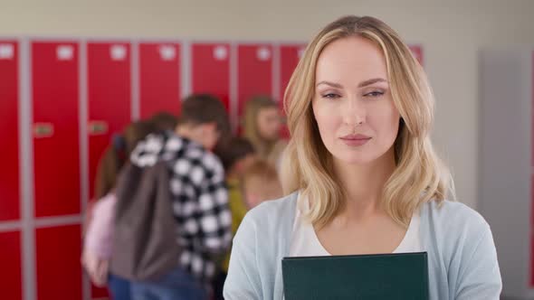 Video portrait of school teacher standing in the school corridor. Shot with RED helium camera in 8K. alt