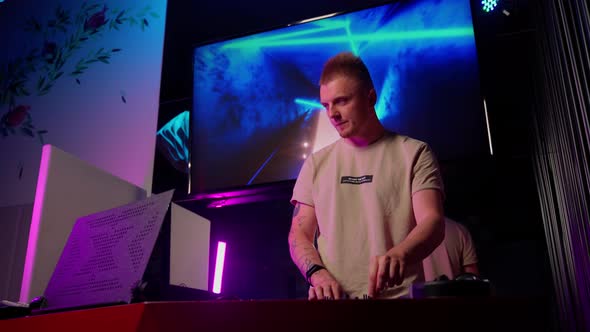 Authentic dj rocking the party up. Disc jockey working in a nightclub, composing a dance music list alt