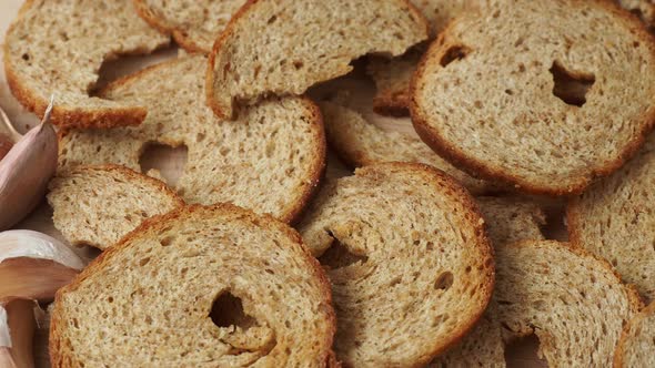 Mini rolls of baked bread and garlic isolated on wooden background