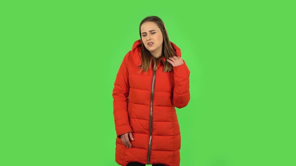 Lovely Girl in a Red Down Jacket Is Upset and Tired. Green Screen alt