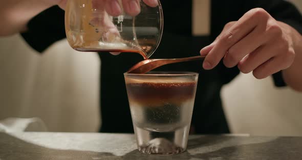 Pour black coffee into tonic water in coffee shop