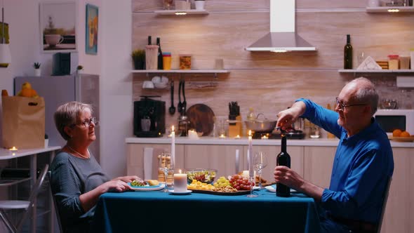 Elderly Man Opening a Bottle of Wine alt