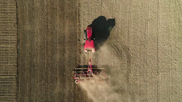 Aerial Top Down View of Tractor Working in the Field with a Modern Sowing Seeds Machine in a Newly