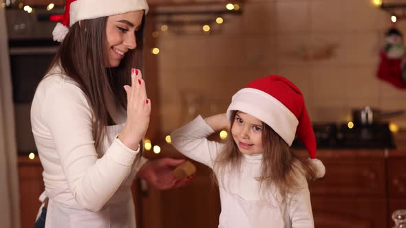 Two Girls in Santa Hat Spent Time Very Happy at the Kitchen alt