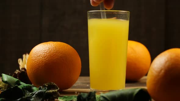 Glass With Ice Cubes Interfere With Orange Juice And Orange Close On The Table