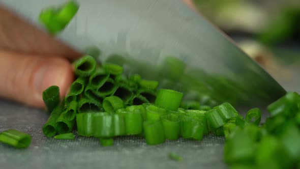 Close Up of Male Chefs Hands Cut Fresh Green Onions with Kitchen Knife
