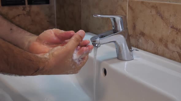 To Prevent Corona Virus or Covid19 a Man Wash His Hands with Soap in Slow Motion alt