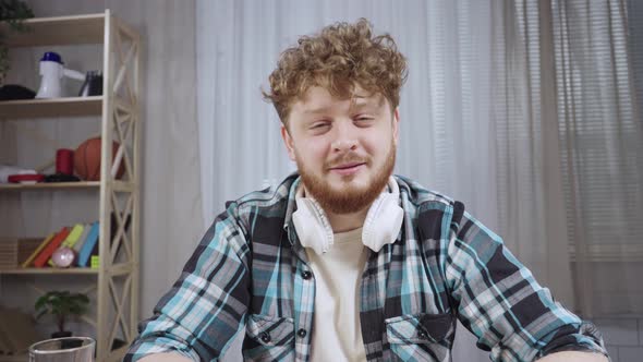 Young Man in Checkered Shirt Shares Information Via Video Communication alt