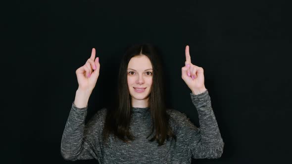 Smiling Brunette Woman Shows Up with Index Fingers on Two Hands