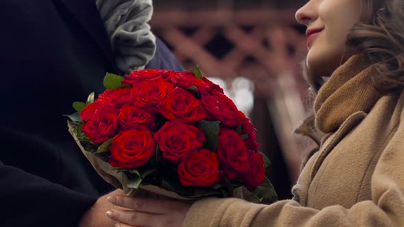 Man Presenting Girlfriend With Bunch of Flowers, Gentle Hugs of Couple in Love alt